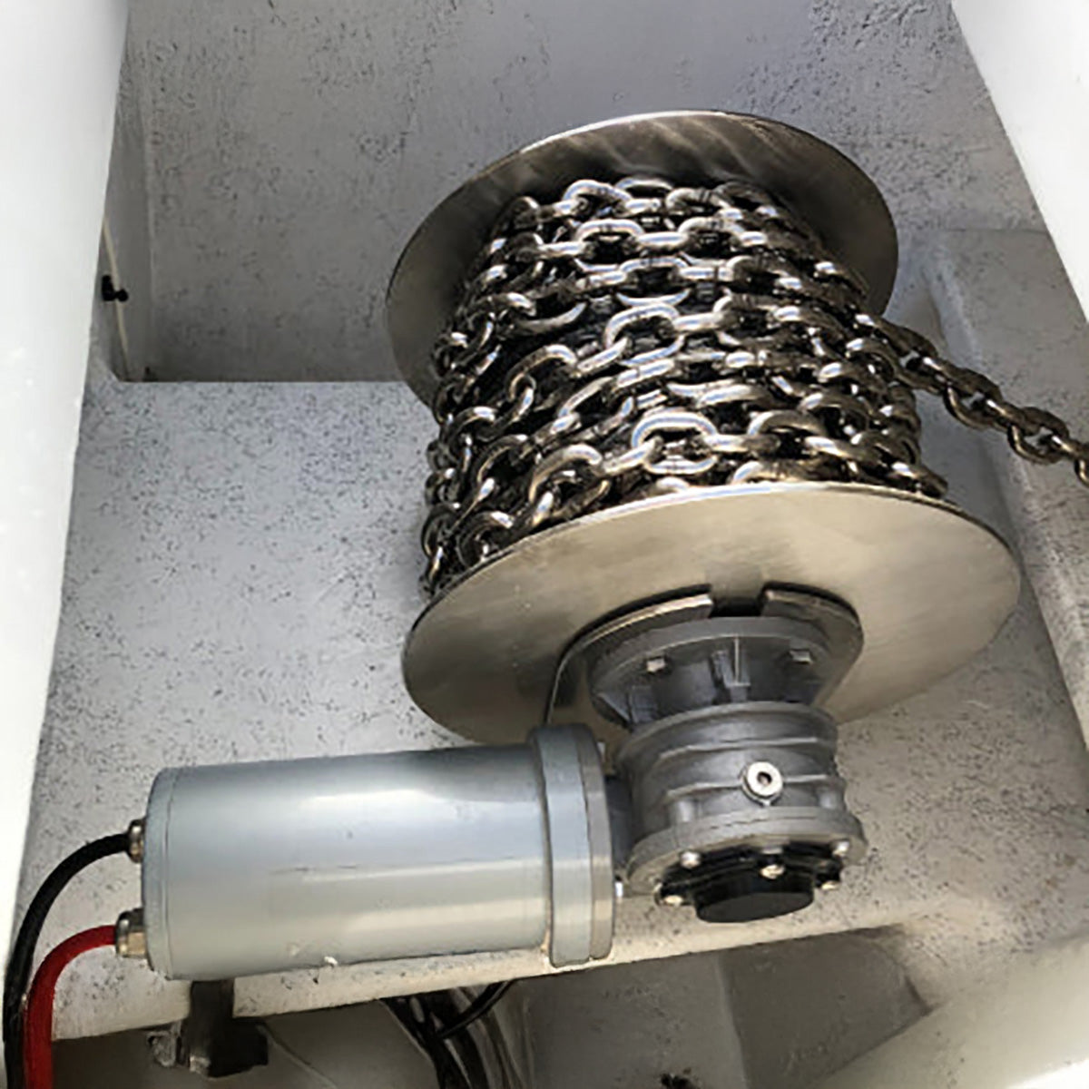 Motorized chain hoist with chain on a concrete floor