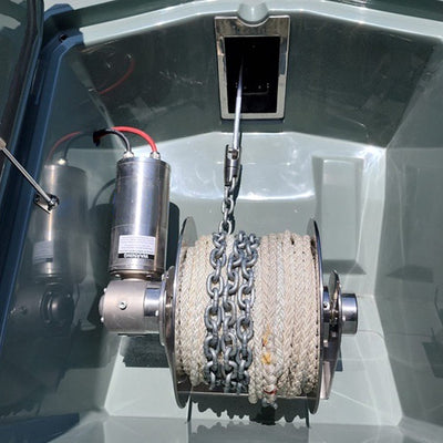 Close-up of a winch with rope and motor in a metallic setting.