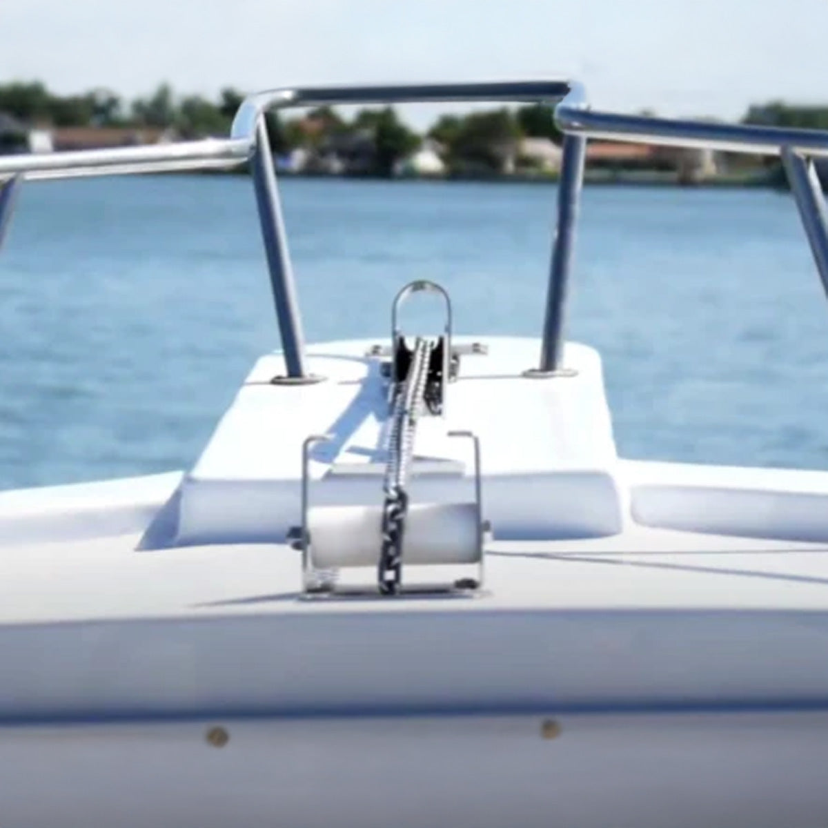 Close-up of a boat's anchor on a sunny day with water in the background